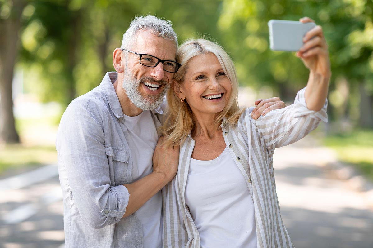 Smiling older couple taking a selfie outdoors