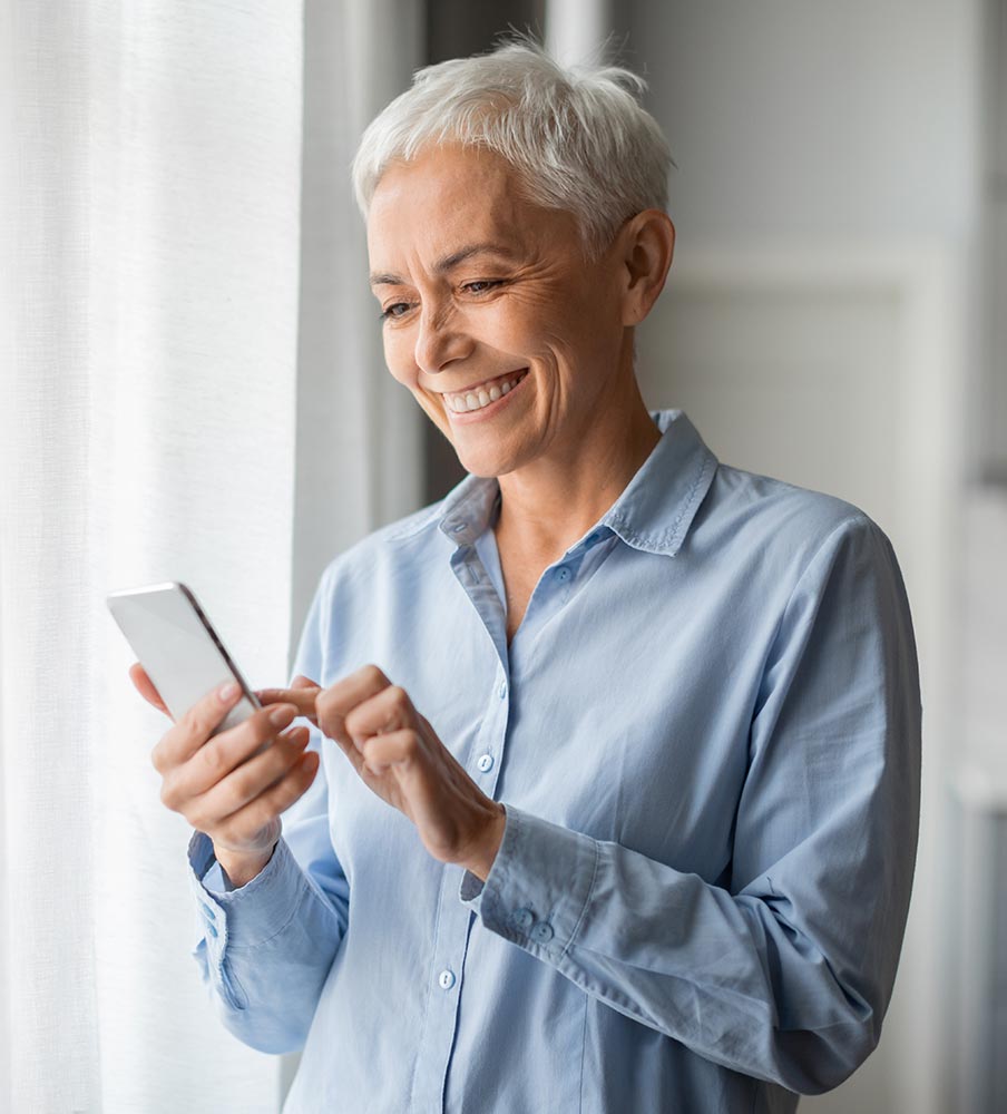Woman smiling while reading on her phone