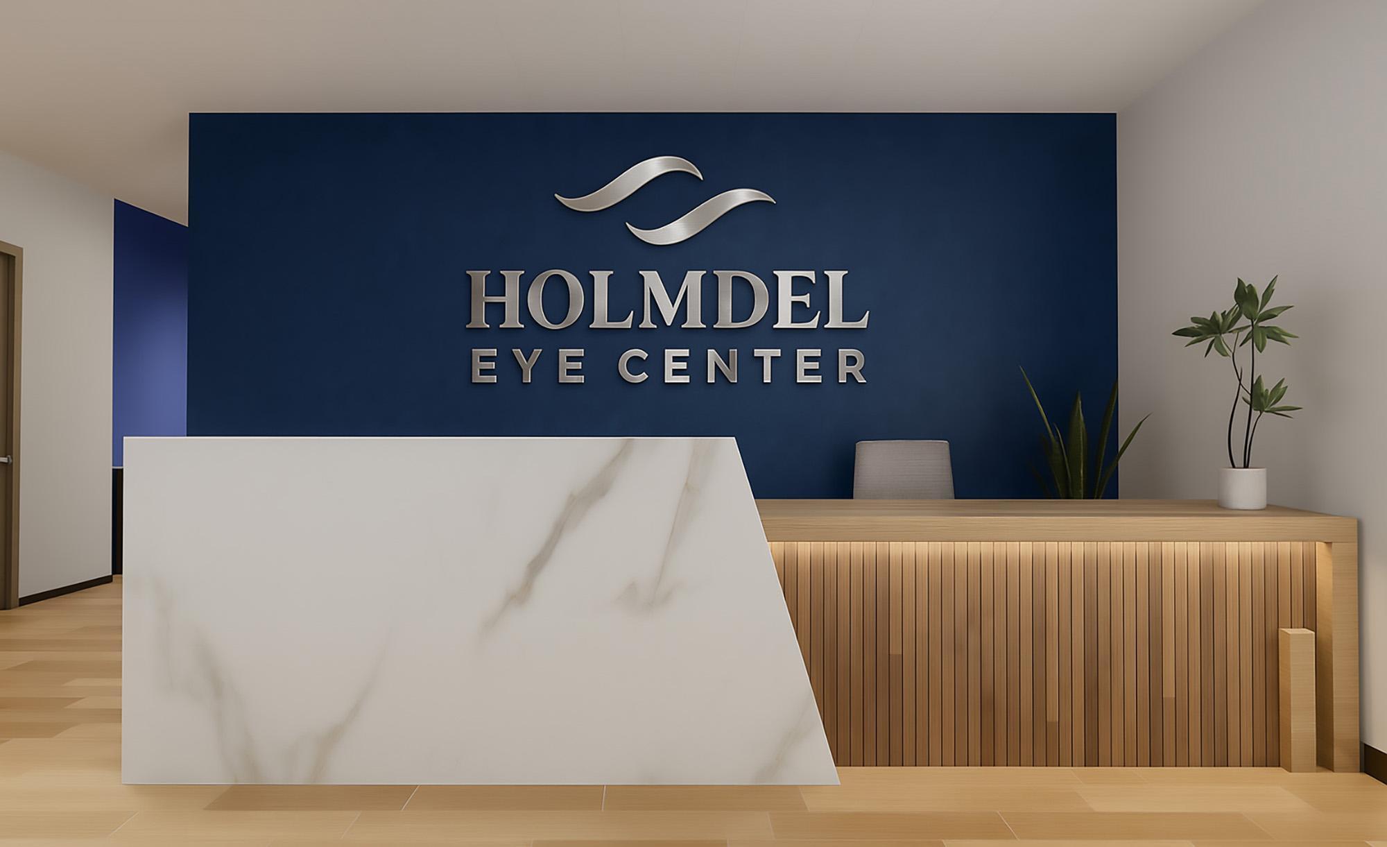 Holmdel Eye Center reception desk with the practice logo on a navy wall