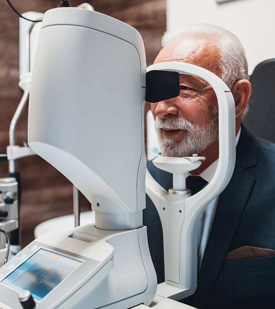 Older man looking into an eye exam instrument