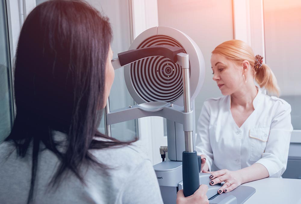 Patient having an eye exam with diagnostic equipment