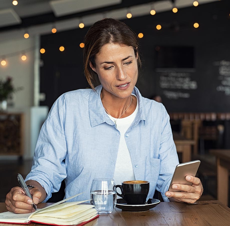 Woman reading on her phone at a cafe
