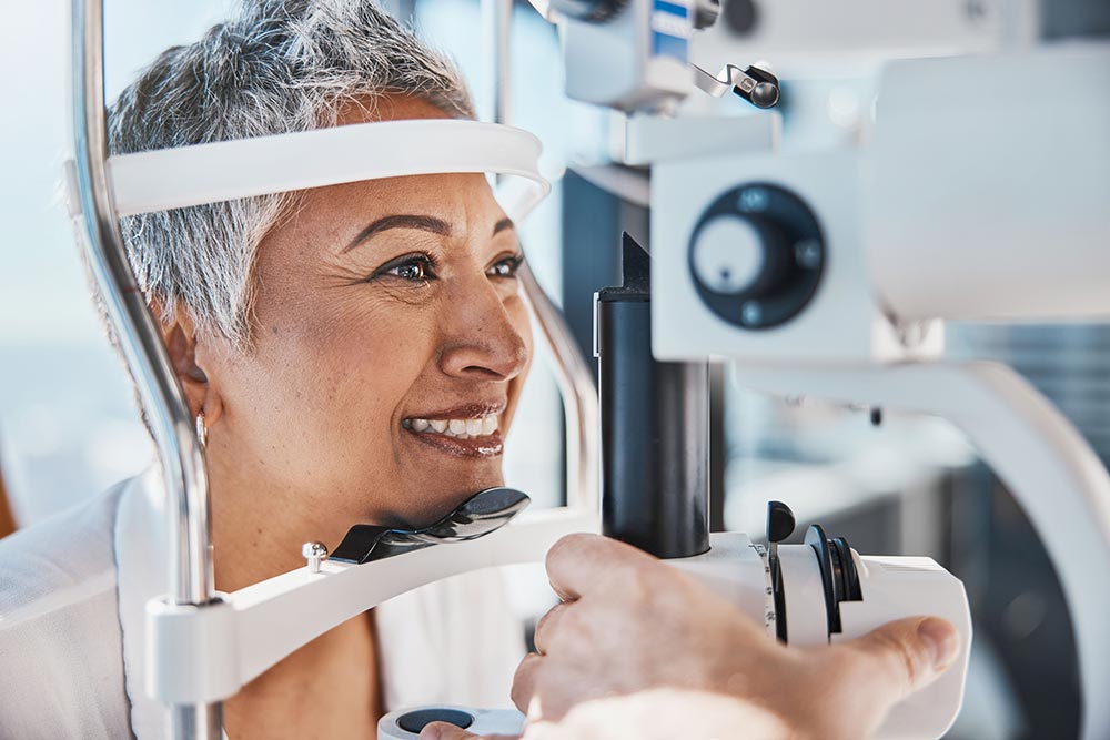 Smiling woman having her eyes examined at a slit lamp